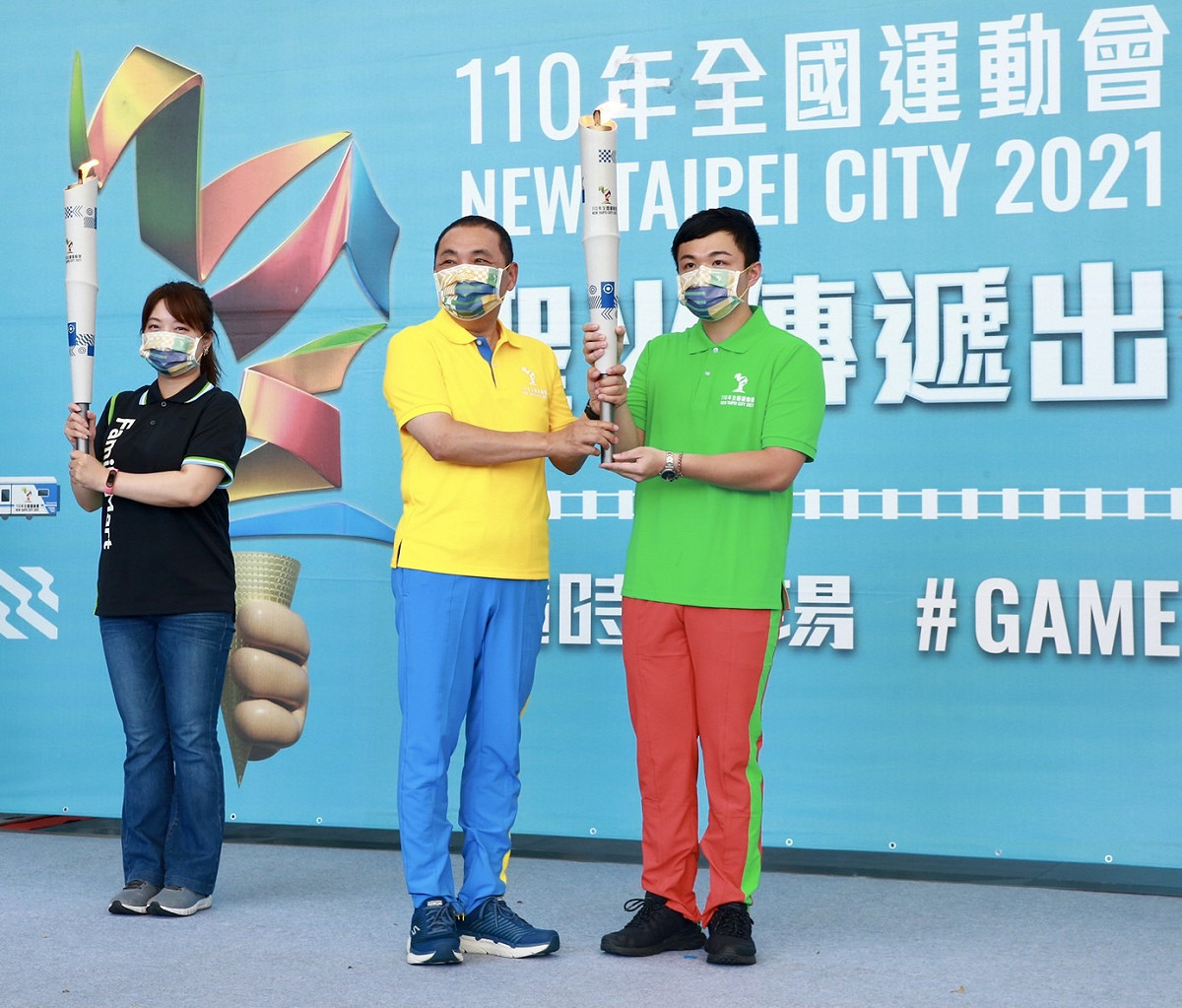侯友宜將火炬交給公路傳遞火炬手尤偉檁。 圖：新北市體育處提供