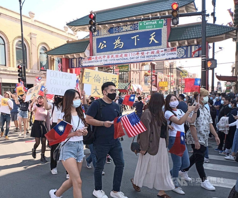 芝加哥中華會館當地時間9日舉辦雙十國慶遊行，民眾手持中華民國與美國國旗，行經華埠地標「天下為公」牌樓。 圖/中央社（駐芝加哥辦事處提供）