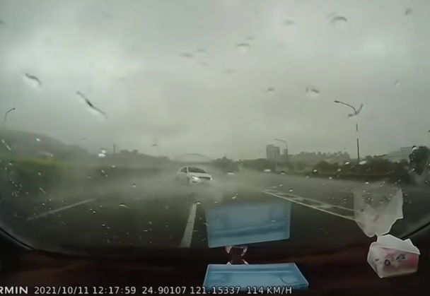 一輛白車行駛在內線車道，未料卻不慎打滑失控。 圖:翻攝自記者爆料網