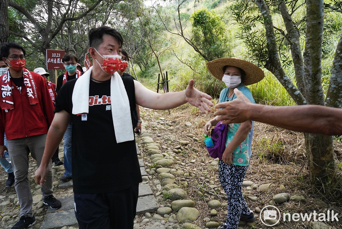 陳柏惟在南寮登山步道和登山健行民眾握手。 圖：張良一/攝