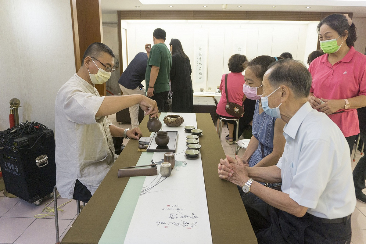 蕭董事長與貴賓們品嘗專業茶師的茶席。 圖：萬和宮/提供