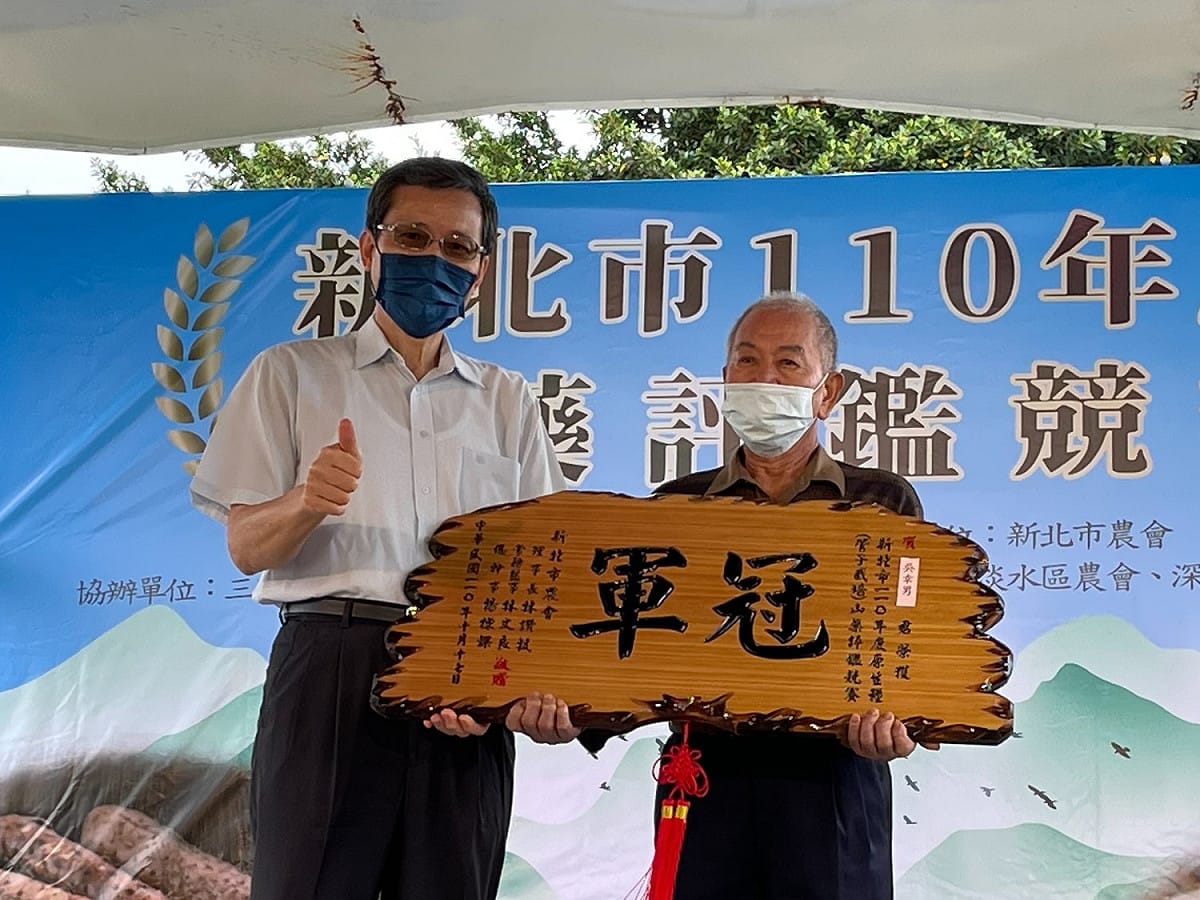 新北農業局施得仰主任秘書(左)致贈冠軍獎牌予原生種(穴管栽培)組冠軍吳幸男(右)。 圖：新北市農業局提供