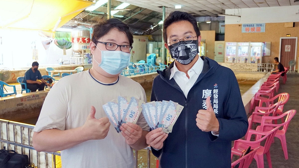 廖泰翔(右)到釣蝦場宣導高雄券的使用。 圖：高市經發局提供