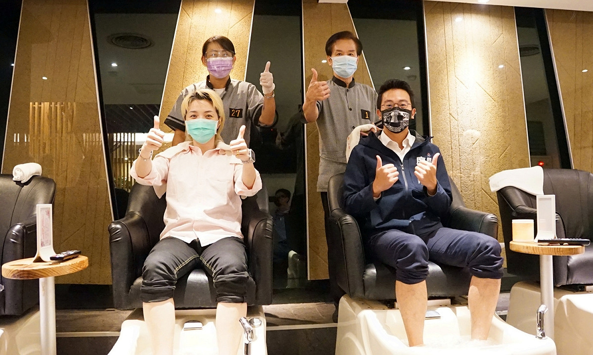 廖泰翔(右)到腳底按摩宣導高雄券的使用。 圖：高市經發局提供