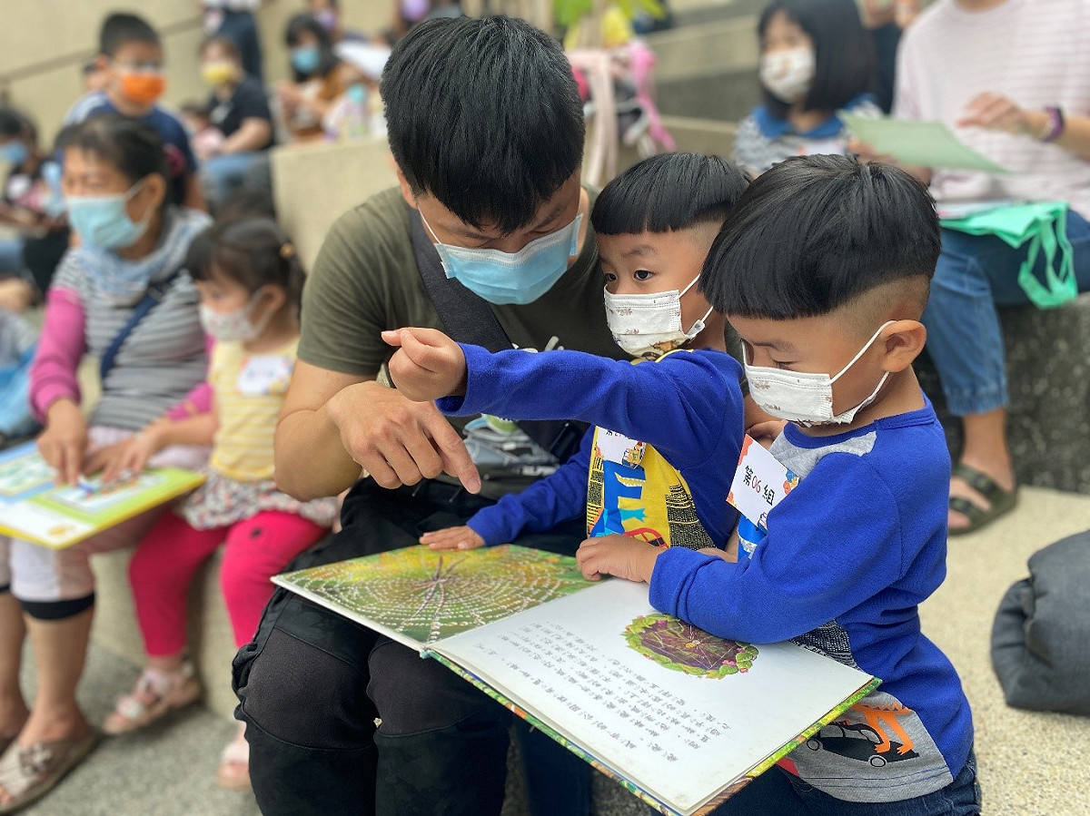 小朋友開心拿著繪本跟爸爸一起看。 台中市政府文化局/提供