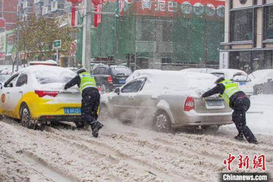 暴雪、寒潮狂襲中國大陸，多省發布緊急通知：停課！停運！停航！圖為車輛受困道路，警察協助排除。 圖：翻攝中新網