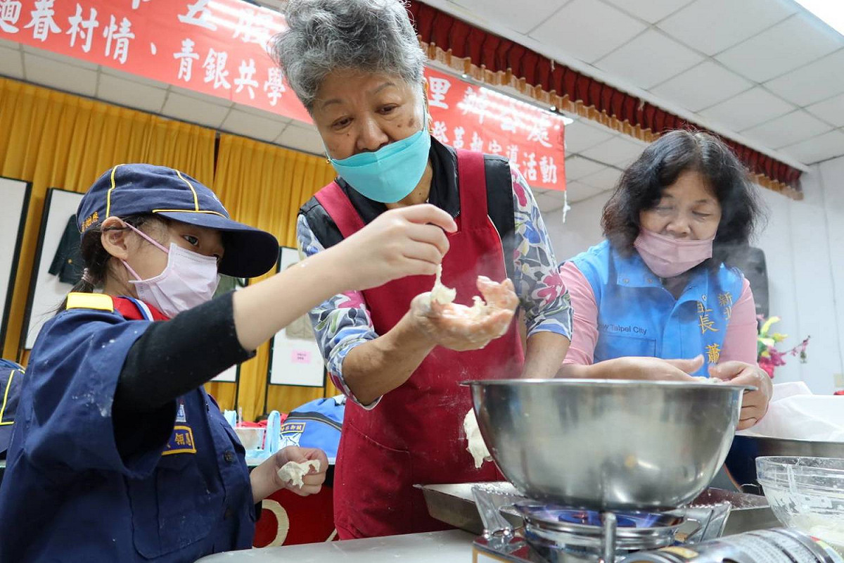 昝姜老奶奶 (中)表示，這次除了讓小朋友學習搓揉麵糰、醒麵、揉出條狀麵糰到捏。 圖：新北市民政局提供
