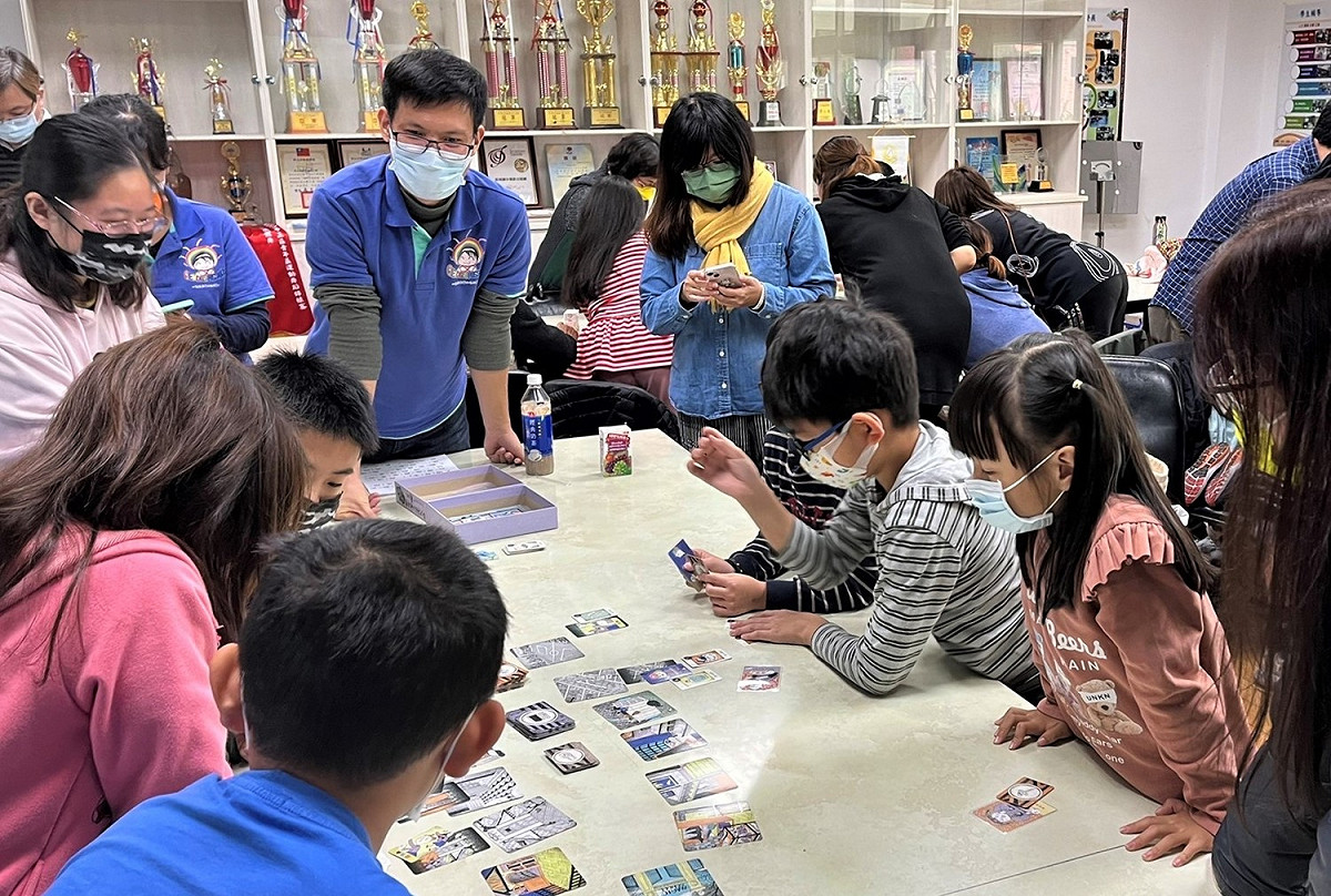 輔導團教師引導親子進行桌遊，學生與家長皆摩拳擦掌、避開危險破關。 圖：新北市教育局提供