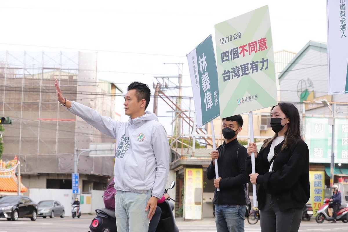 民進黨新人林義偉在大雅區昌平、雅潭五叉路口，舉起「四個不同意，台灣更有力」標語，呼籲民眾在12月18日的公投，投下四個不同意票。 林義偉/提供
