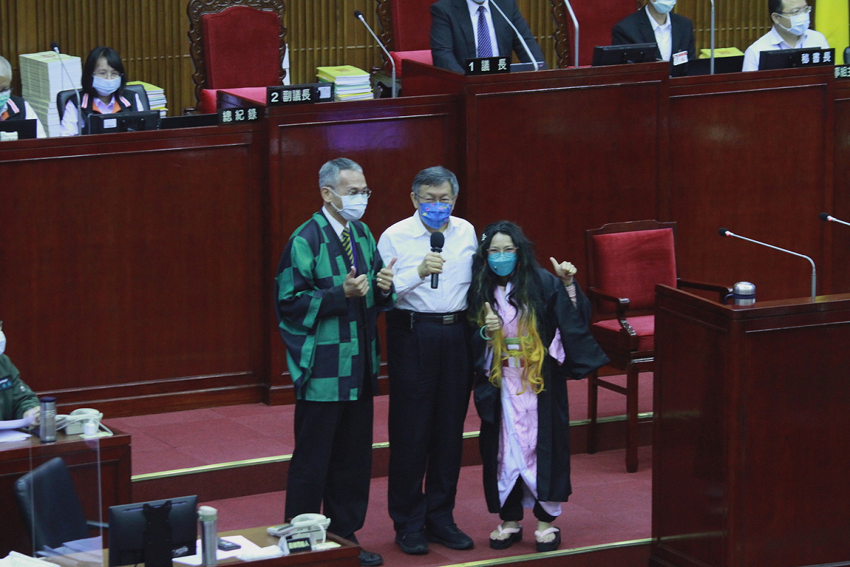 國民黨議員郭昭巖（右）扮演禰豆子，與台北市長柯文哲（中）、穿上炭治郎外套的北市府參議陳慶安（左）合影。 圖：周煊惠 / 攝