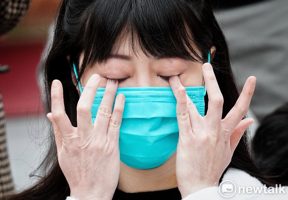 高嘉瑜在記者會中用雙手拭去臉上的淚水，她的脖子和雙手依稀可以看到受暴後留下的傷痕。 圖：張良一/攝