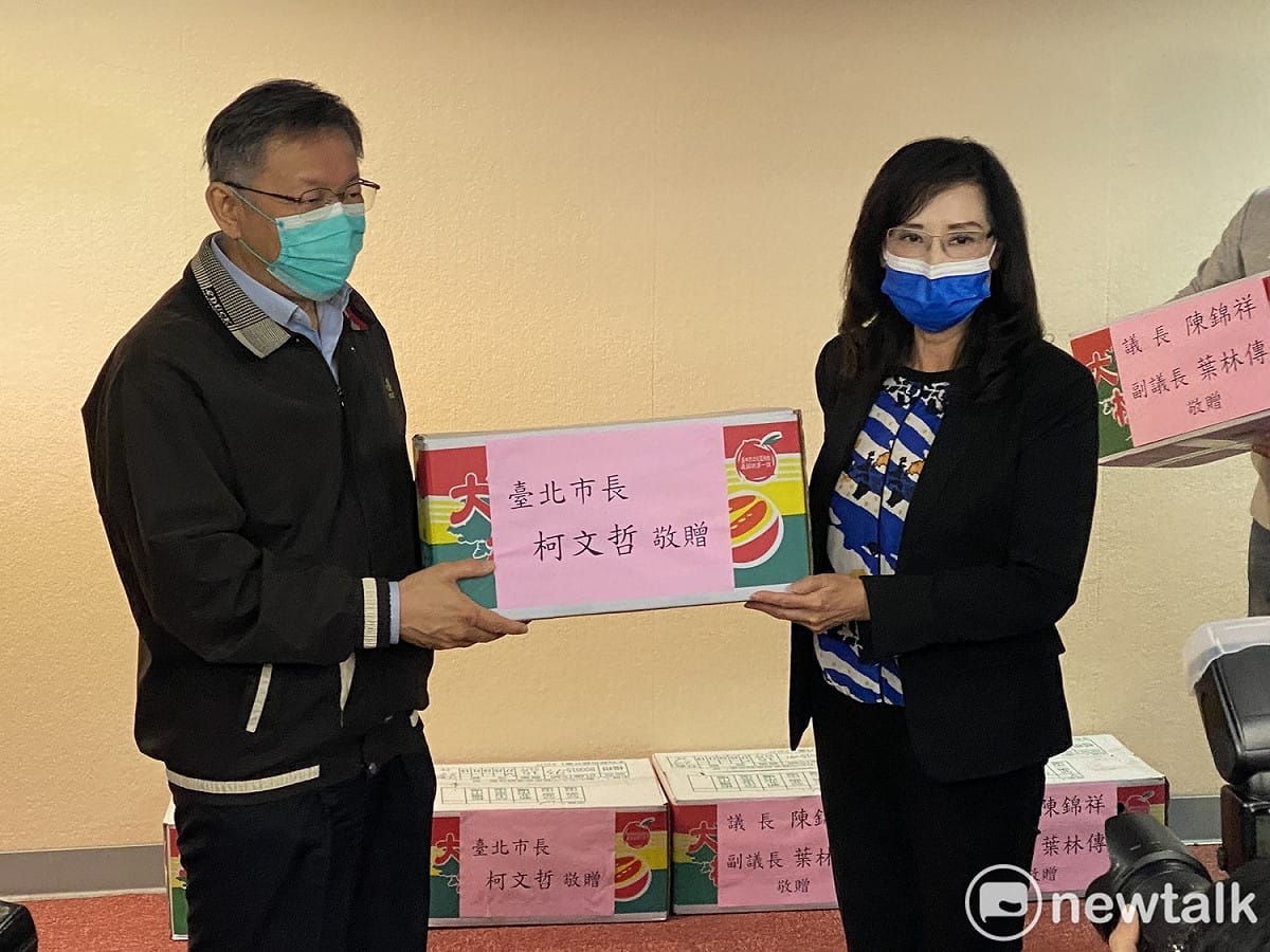 台北市長柯文哲（左）贈送水果給台北市議會各委員會，國民黨台北市議員秦慧珠（右）收下。 圖：周煊惠 / 攝