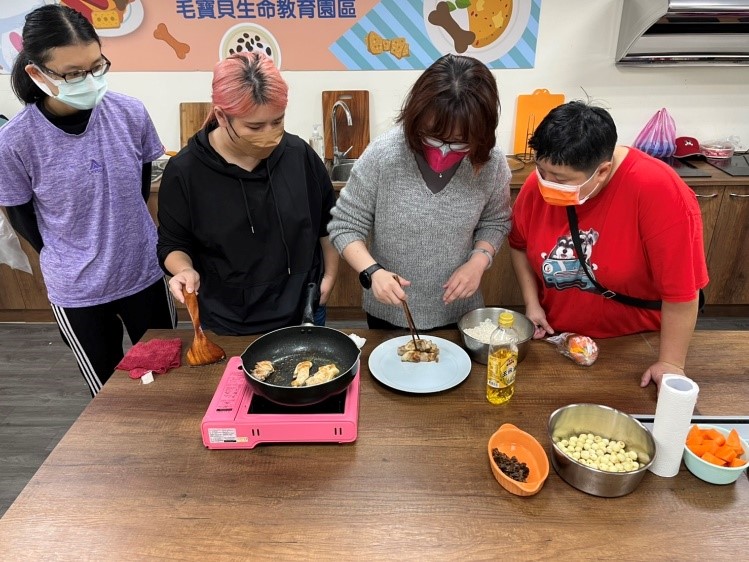 飼主認真地看著陳臻老師示範烹煮「福圓安神燉雞腿」料理。 圖：新北市動保處提供