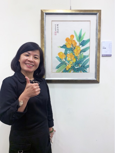 新秀會員－陳素真與作品〈黃金滿樹〉合影。 圖：新北市文化局提供