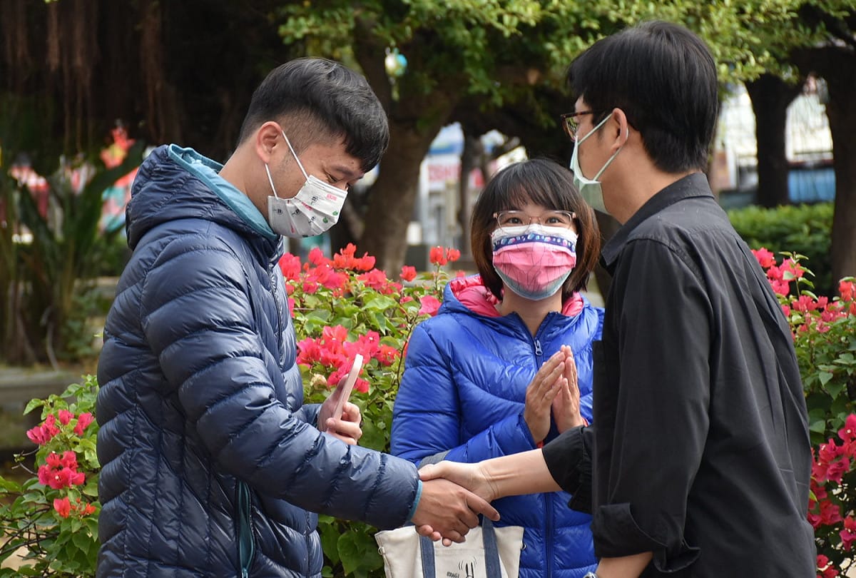 陳其邁(右)與年輕選民握手。 圖：孫家銘攝