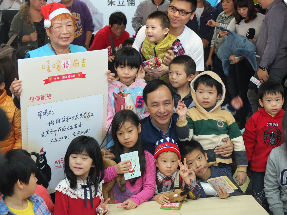 國民黨總統候選人朱立倫20日出席總部親子日活動，但與小朋友合照時，小朋友一開始都比出YA，似乎是在比2號。 圖：翁嫆琄/攝