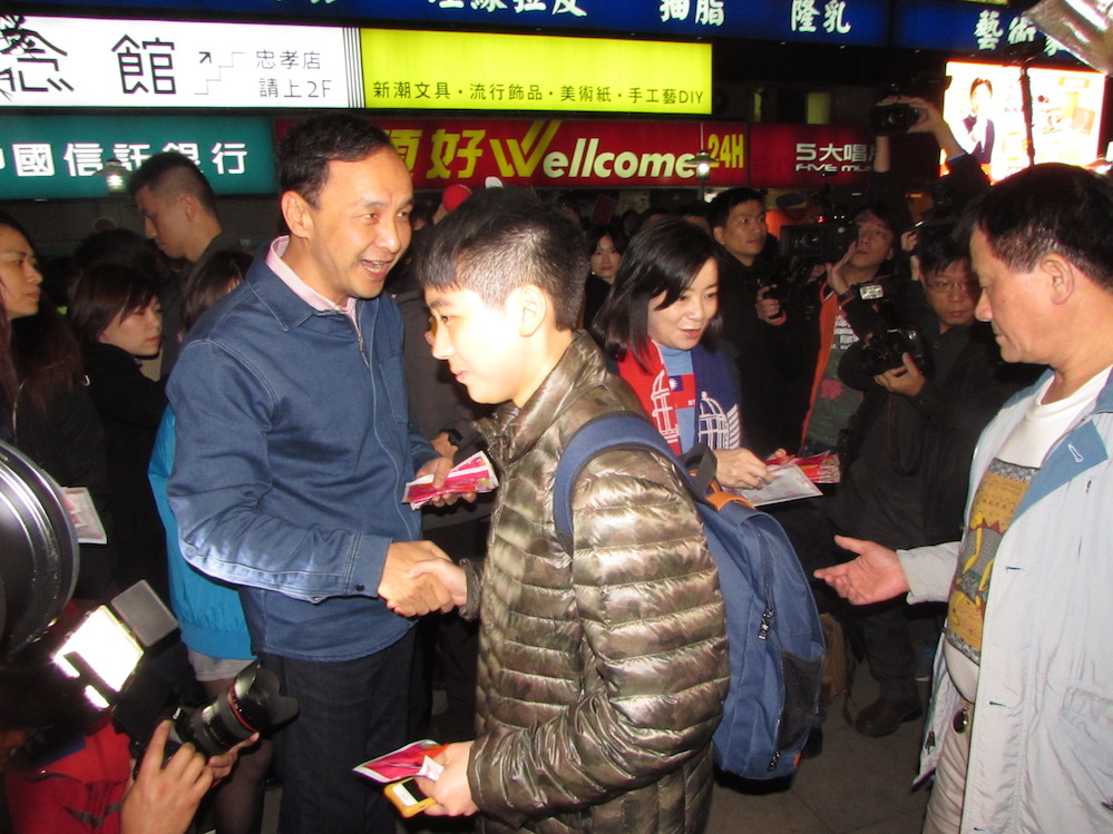 國民黨發起跨年夜送暖活動，國民黨總統候選人朱立倫與夫人高婉倩31日晚間前往台北市頂好廣場發放暖暖包。 圖：邱珮文/攝