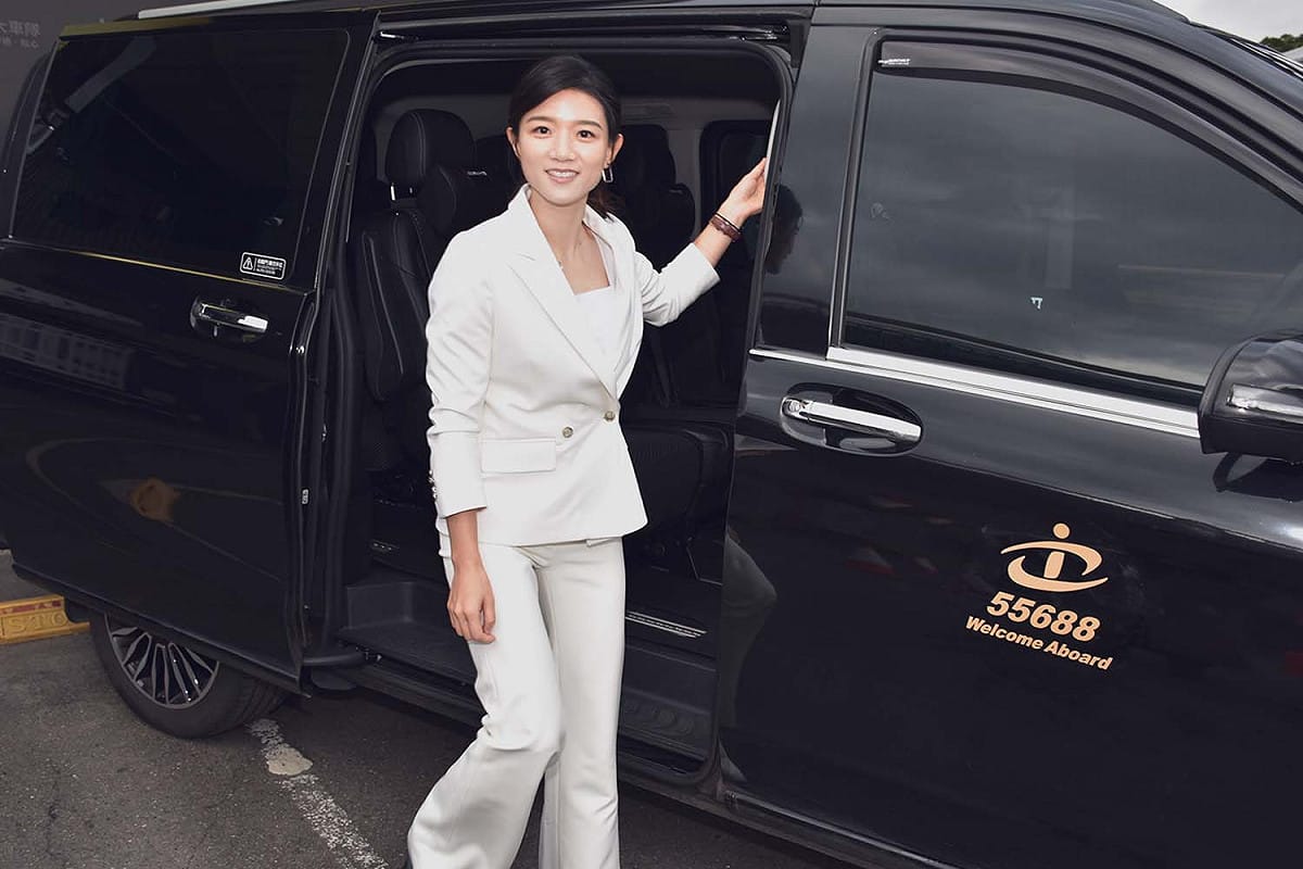 台灣大車隊執行長林念臻，穿著一身白色勁裝，搭乘頂級商務車款的多元計程車，南下考察「台灣燈會在高雄會前會」之雙舞台跨年晚會的5G技術異地共演。 圖：台灣大車隊／提供