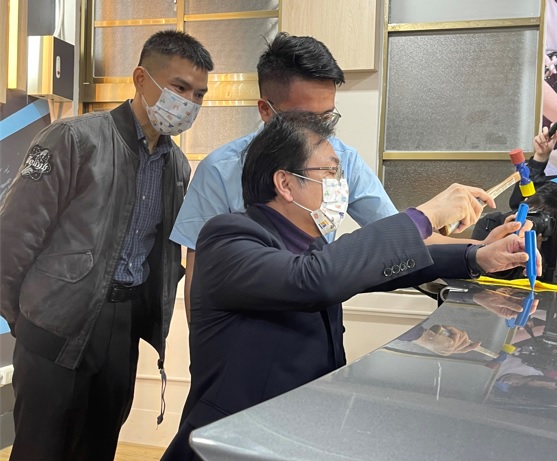 金牌選手方宣又(右)向新北副市長劉和然示範說明車門微板金修護技術，左為卓越凹痕修護執行長馬成傑。 圖：新北市教育局提供