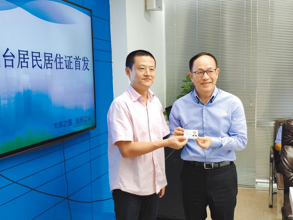湖南「長沙台胞投資企業協會」會長林懷(圖右)，涉違反《總統副總統選舉罷免法》判處3年10月徒刑，褫奪公權4年。圖為2018年林懷在長沙領取台灣居民居住證。 圖：翻攝中新社(資料照片)