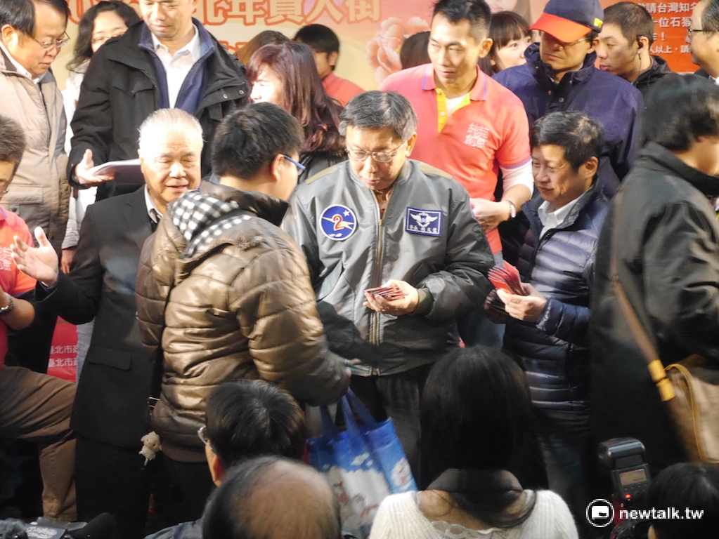 台北市長柯文哲2日下午在「2016臺北年貨大街」台北地下街發送發財金。 圖：劉奕霆/攝