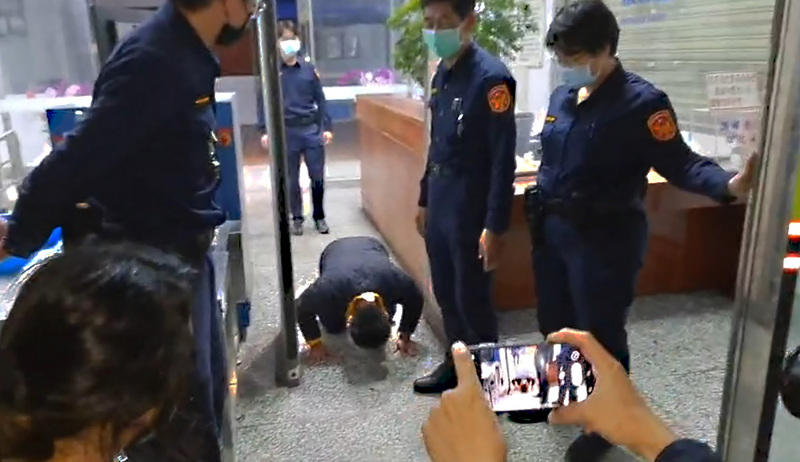台鐵太魯閣號事故被告李義祥（跪地者）21日晚間完成交保，欲離開時等候在外的罹難者家屬激動上前要他道歉，場面混亂，李義祥一度被推倒，隨後狼狽跑回地院，約30分鐘後再次走出，向家屬下跪磕頭連說「對不起」。 圖：民眾提供