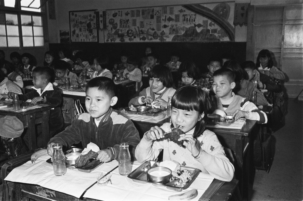 1982年學童營養午餐喝牛奶的檔案影像，見證台灣人飲食選擇趨向多元。 圖：國家發展委員會檔案管理局提供
