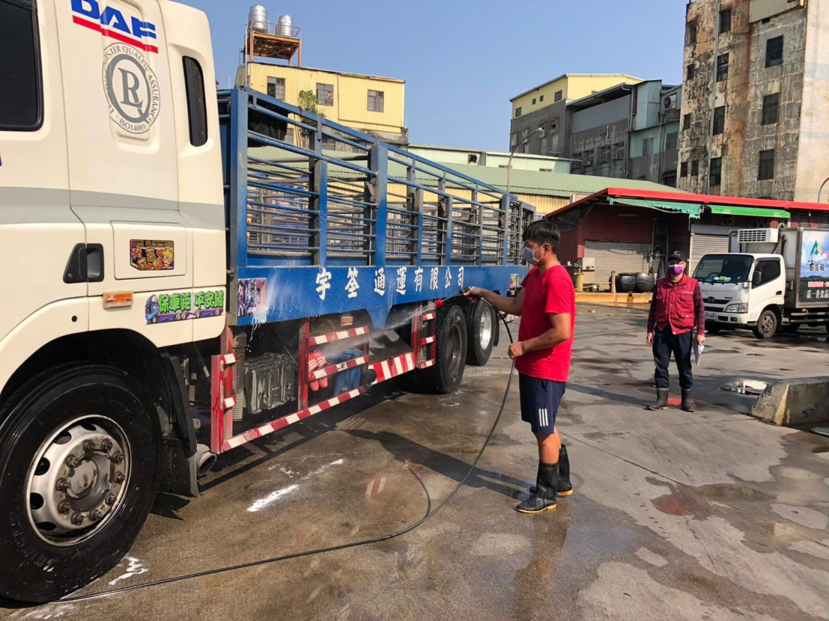 動保處防疫人員督導肉品市場運豬車司機落實清潔消毒工作。 圖：新北市動保處提供