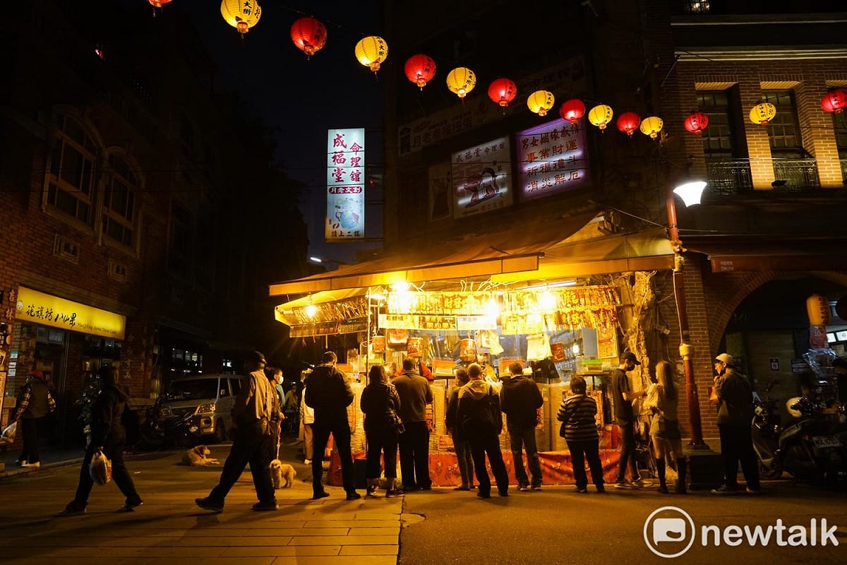 一些民眾在攤子前挑選瓜子、開心果的應景食品。 圖：張良一/攝