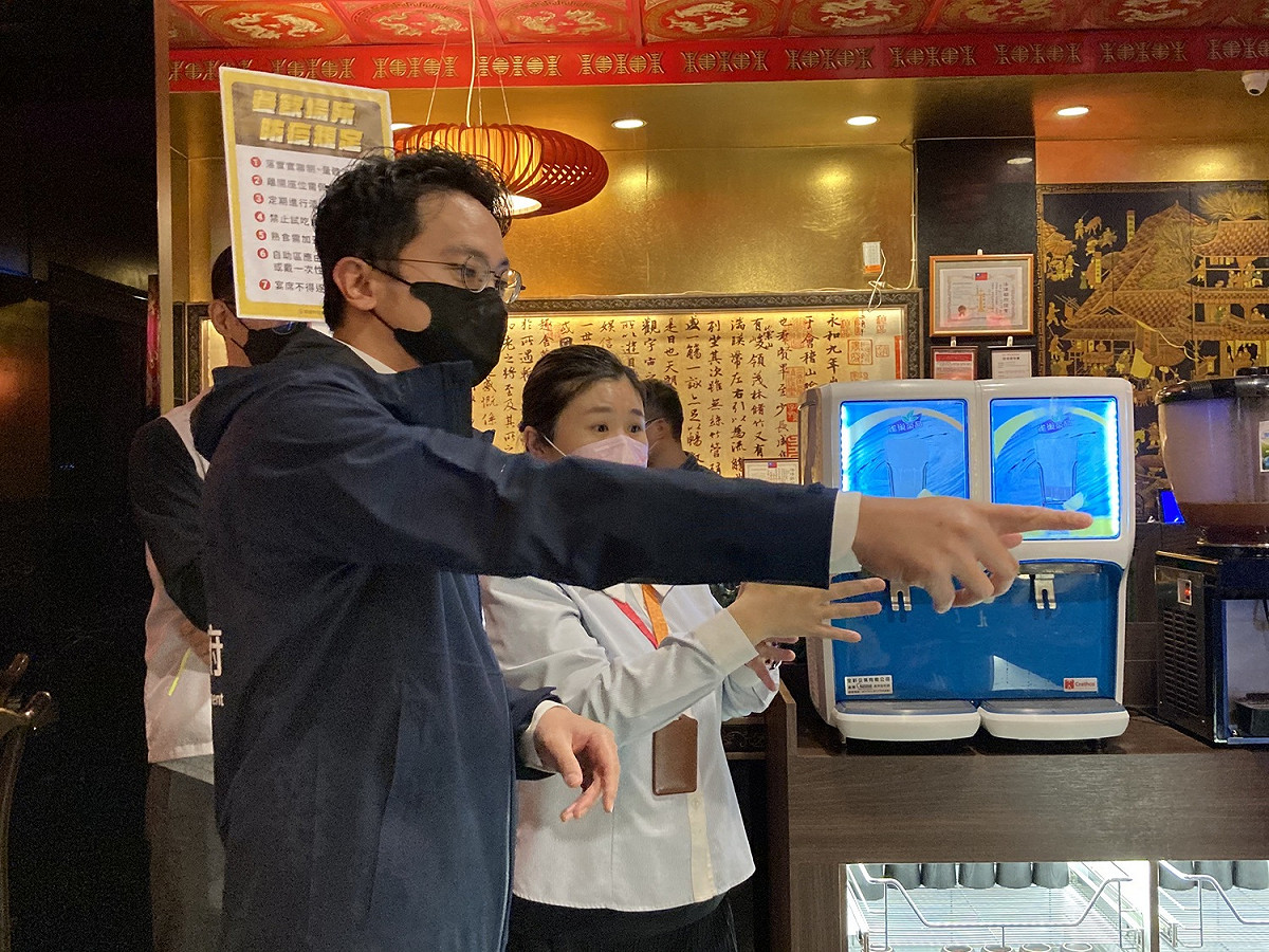 廖泰翔(左)稽查店家並宣導最新防疫規定。 圖：高雄市經發局提供
