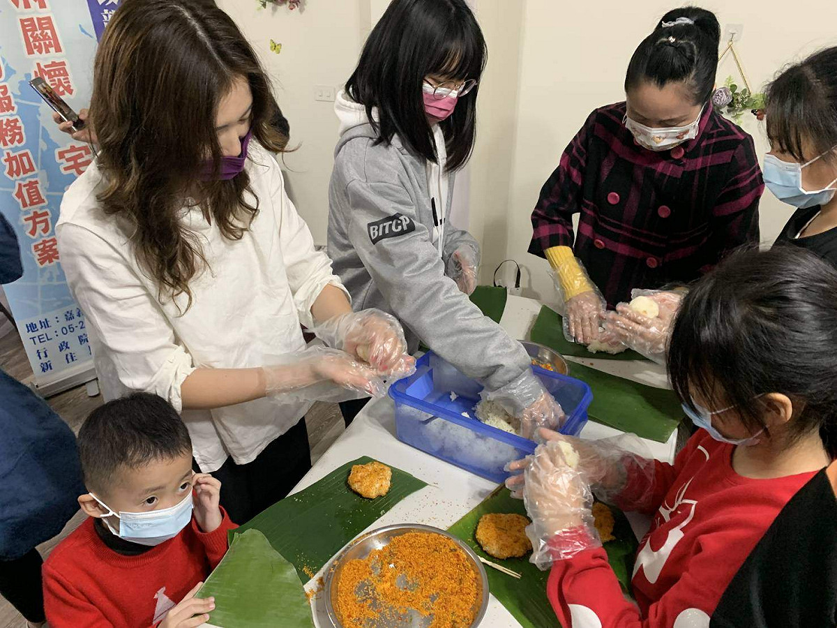 來自大陸的新住民姐妹（白色衣服者）帶著孩子一起製作印尼飯糰，提前過新年。 圖：嘉義移民署/提供