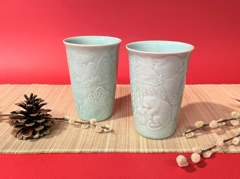 安達窯推出的「猛虎青瓷對杯」，杯身跋山取麥穗的猛虎，祝福順利闖過瞬息萬變的新年。 圖：鶯歌陶瓷博物館提供