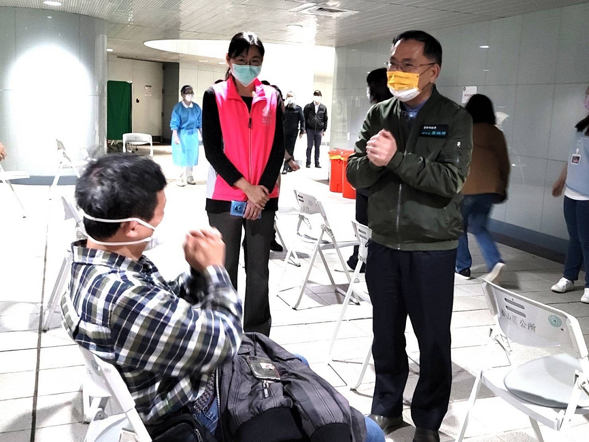 台北市副市長蔡炳坤視察捷運松山站疫苗接種站，向民眾拜年。 圖：台北市政府 / 提供