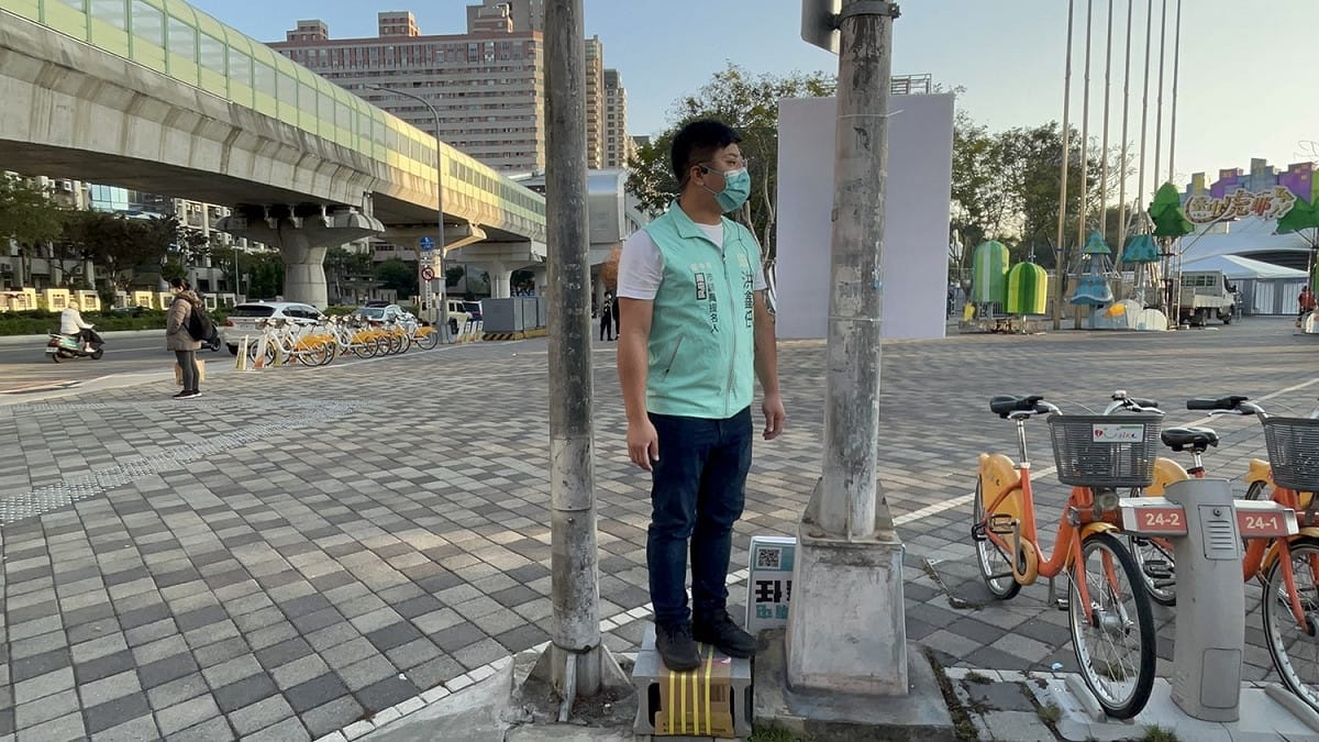 洪鑫任選擇站在紅綠燈及路燈中間，意喻要在夾縫中求生存。 洪鑫任/提供