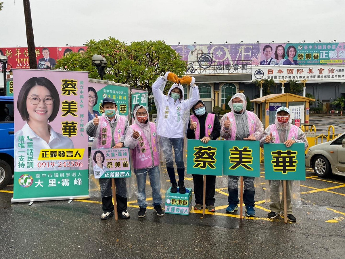 蔡美華冒雨在街頭向選民問候爭取支持。 蔡美華/提供