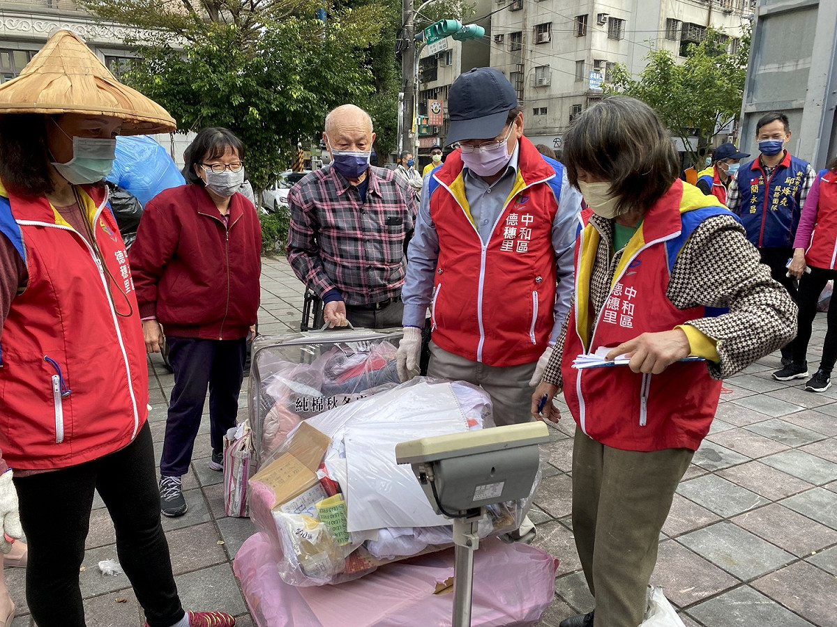 德穗里志工們服務民眾資源回收秤重兌換點數。