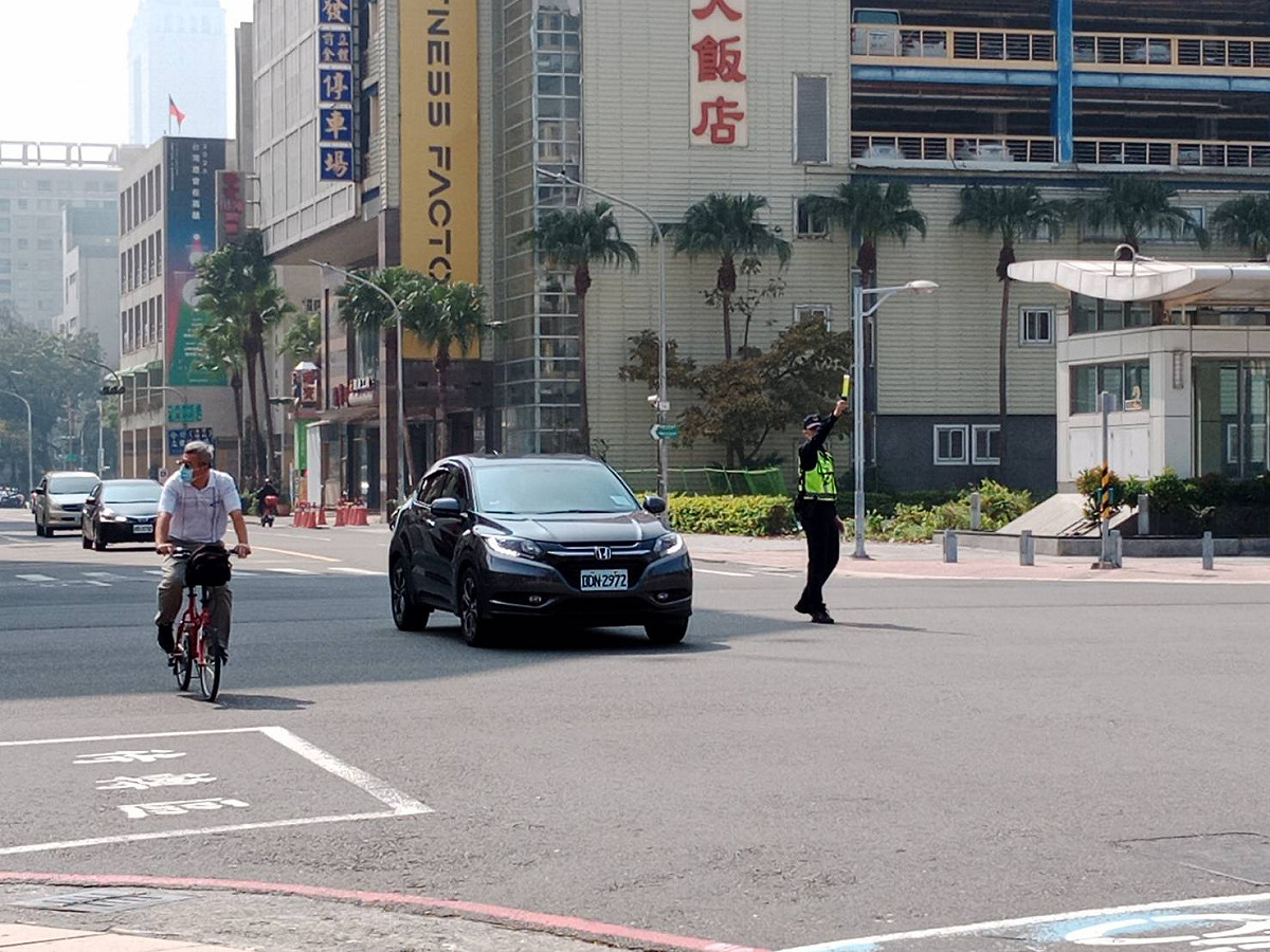 高雄市路口號誌燈不亮，交警忙著指揮交通。 圖：孫家銘攝