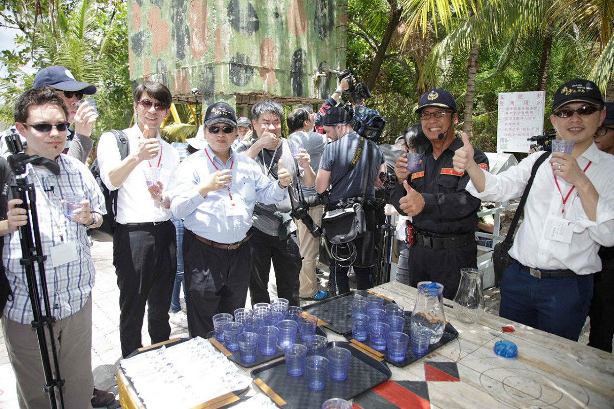 外交部23日首度邀請外國媒體登太平島參觀，圖為國內外媒體記者聆聽農業工程研究中心環境組組長張大偉水質簡報並試飲井水。 圖：外交部提供