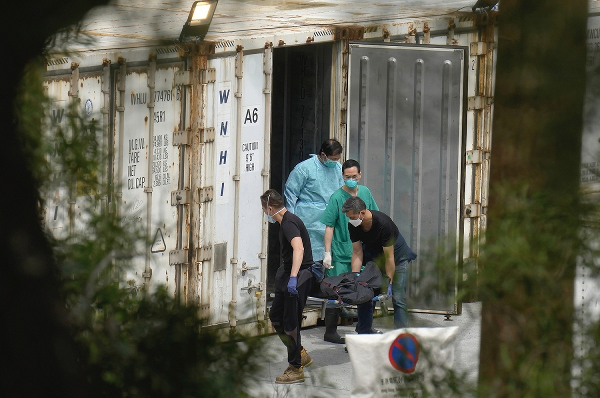 6日，香港沙田富山公眾殮屍房，工作人員將確診者屍體從冷藏貨櫃中搬移上靈車。 圖：達志影像/美聯社