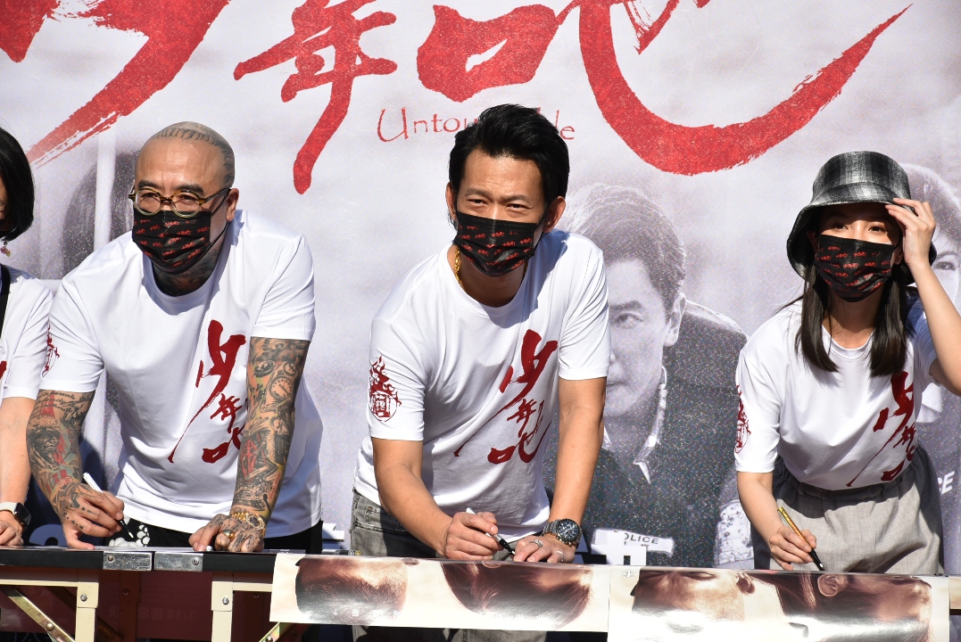 顏正國(中)與李千那(右)等現場簽名。 圖:孫家銘攝