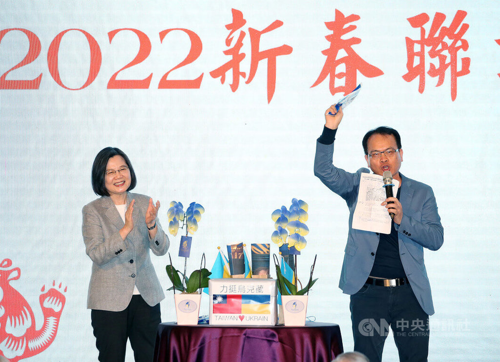 總統蔡英文（左）13日出席「台灣之友會感恩迎新春聯歡之夜」，現場由媒體人鄭弘儀（右）主持義賣，拍賣蔡總統親筆簽名的烏克蘭國旗顏色式樣口罩，5袋口罩拍賣所得新台幣52萬元捐給烏克蘭。 圖：中央社提供