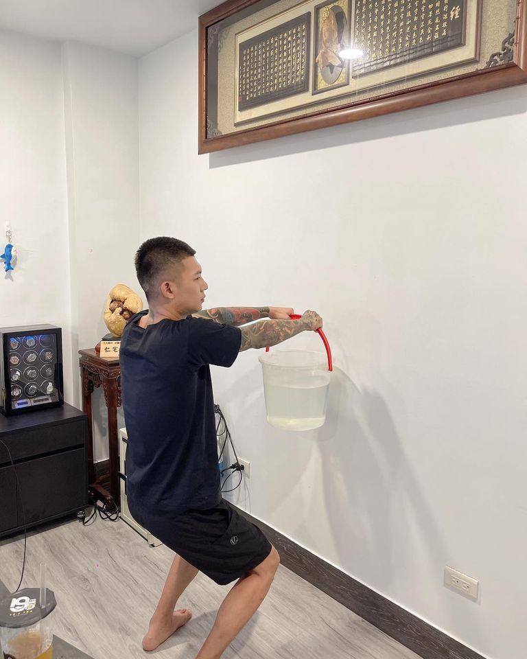 鳳梨臉書突然貼出一張他手提水桶面壁半蹲的照片。  圖：翻攝自鳳梨臉書