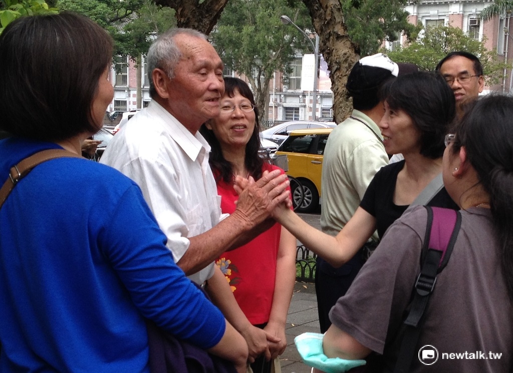 台南鐵路東移自救會成員(後右一)為大埔拆遷戶年紀最長的83歲住戶黃福記加油打氣。 圖：周富美/攝
