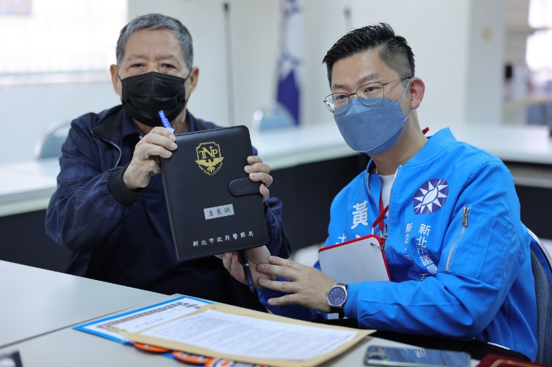 已故議員唐慧琳的父親唐敦舜，則是在現場拿出一本唐慧琳當年的工作筆記，象徵理念與經驗的傳承 圖：黃心華服務處提供