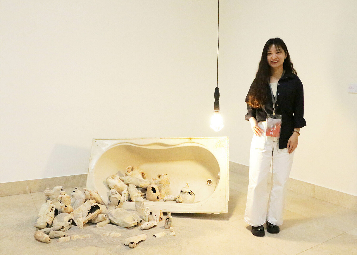 「2022新北市美術家聯展」匯集老中青藝術家一起共襄盛舉，最年輕得獎者為去年新北市美展雕塑類首獎得主許文齡，與其作品「沐浴，沐慾」一同合影。 圖：新北市文化局提供