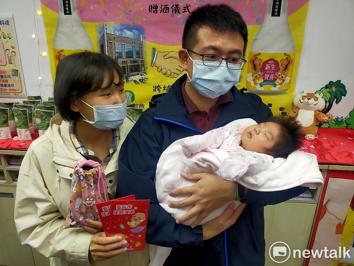 周姓市民與太太抱著出生40天的女兒辦妥出生登記，馬上領到生育津貼及紀念酒。 唐復年/攝