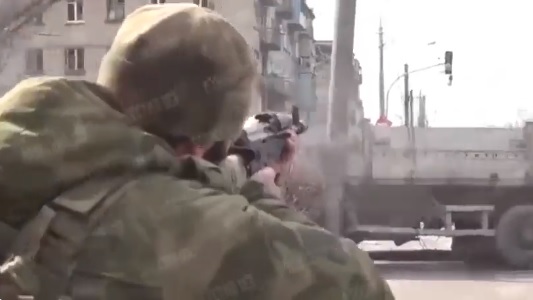 三名車臣士兵手拿武器攻擊紅綠燈。 圖：翻攝自推特