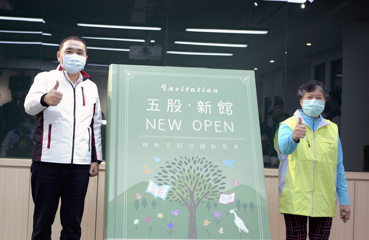 侯友宜與五股分館的資深志工一起揭開大書象徵五股分館啟用。 圖：新北市立圖書館/提供