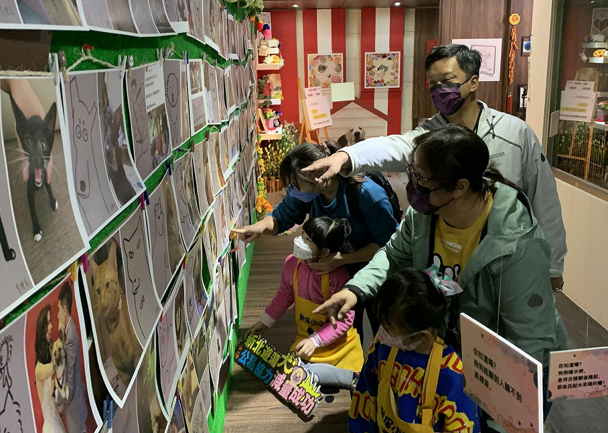 家長陪同小朋友們一同參觀園區展出的網路插畫名家「隨便畫小姐」200幅毛寶貝療育形象圖作。 圖：新北市動保處提供
