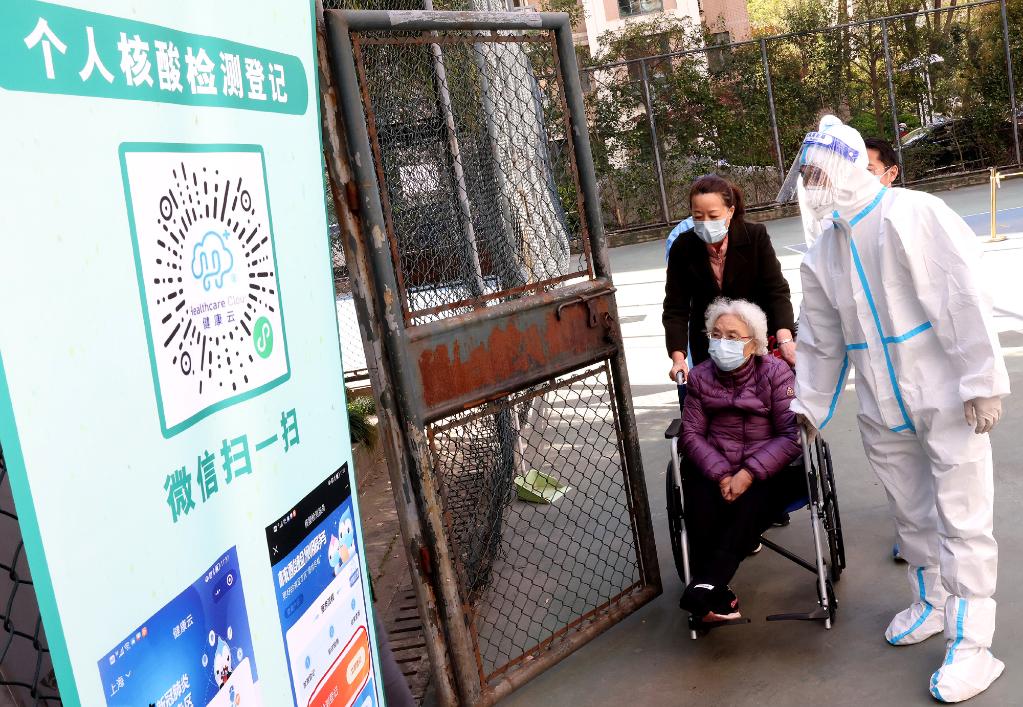 上海確診人數遽增，中國動用35000檢驗人員，拚單日篩檢全上海2500萬人。圖為行動不便老人也依規定排隊篩檢。 圖：翻攝新華社